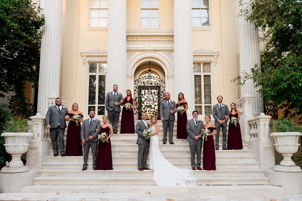 bride, groom and bridal party on front steps of mansion