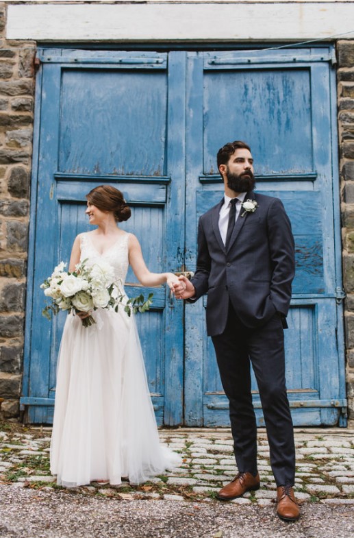 bride and groom in front of blue door